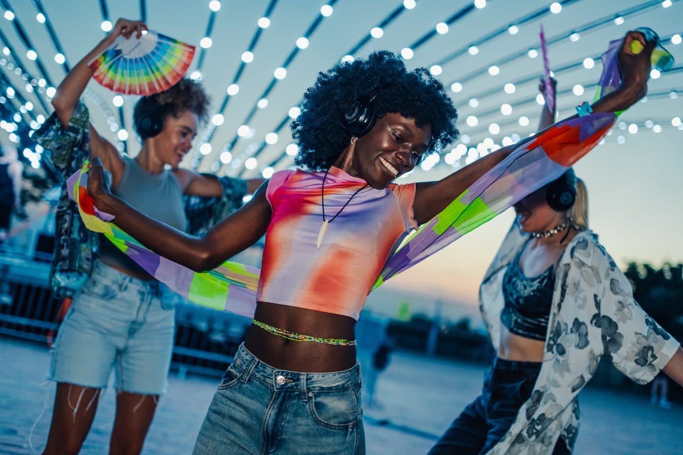 Freunde tanzen nachts draussen zu Musik